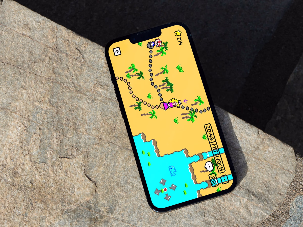 Smartphone resting on grey paving stone shows the yellow pixel playing field of SUPER ME.